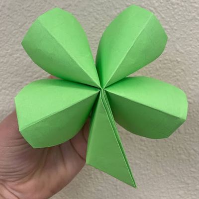 A close up of a green origami paper four leaf clover.