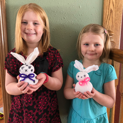 2 kids holding up their rabbit art.