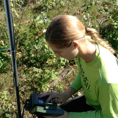 A scientist checks her equipment in the field