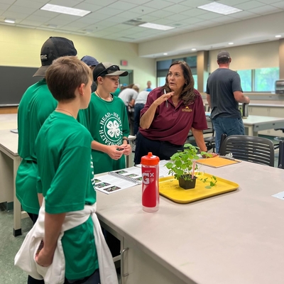 Dean Durgan talking to a small group of youth in a classroom setting with a plant on a table in front of them.