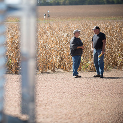 Farmers talking near a grain silo.