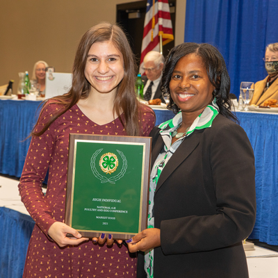 4-H award plaque presented by judge is held by 4-H youth
