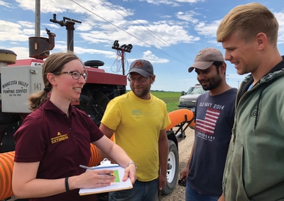 Melissa Wilson with farmer and grad students in front of manure machinery