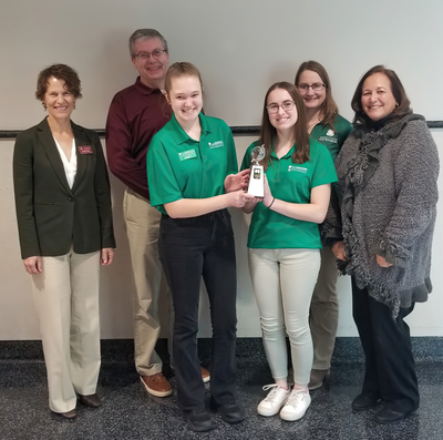 A group photo of Associate Dean Skuza, Extension Educators Brian McNeill and Anja Johnson, Dean Durgen, and two Minnesota 4-H Ag Ambassadors Arabelle R. and Ellie S., holding an award.