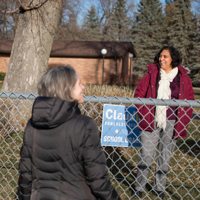 Three female community leaders talking  outside.