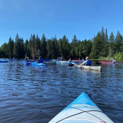 a group of kayakers paddling on a lake