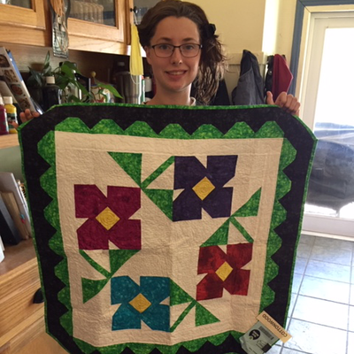 A kid holding a quilt.