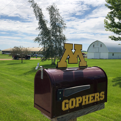Minnesota Gophers mailbox with farm in background.