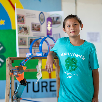 A 4-H'er poses next to a county fair project.