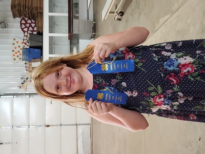 girl holding 2 blue ribbons