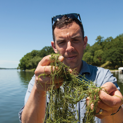 Dan Larkin holding lake weeds