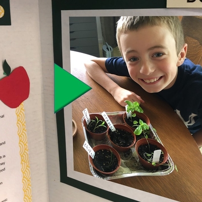 Video play button over photo of child with plants and poster board