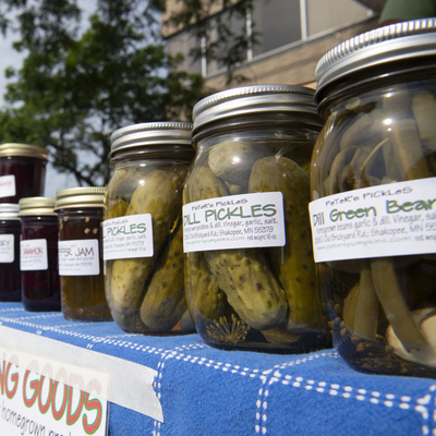Jars of labeled pickles and other canned goods at a farmers market