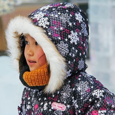 Girl outside in the snow in a coat.