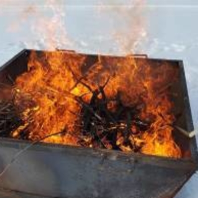 Kiln with branches on fire to make biochar