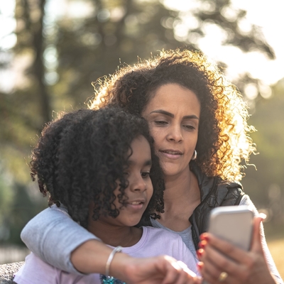 A woman and her daughter check a text. 