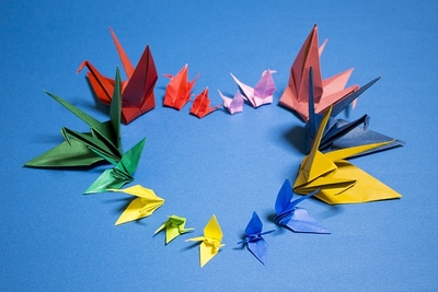 A heart made out of different colored paper origami cranes.