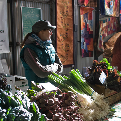 Woman at farmers market produce stand
