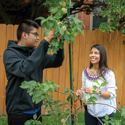 Master Gardener and teen with apple tree