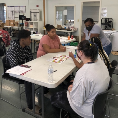 Educator and group of teens learn about money