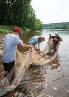 Master Naturalist volunteers removing material from St. Croix river with fish net