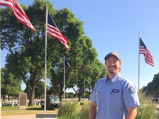 Trevor Blake at Fort Snelling National Cemetery with flags waving