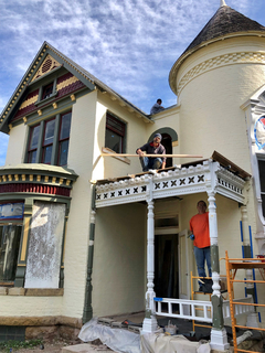 Construction workers restoring the front exterior of the Lewis P. and Lisbeth (Putnam) Hunt House in Mankato, Minnesota.