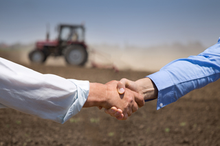 Handshake in a farm field