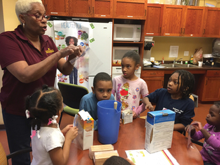 Extension nutrition educator teaching children in kitchen