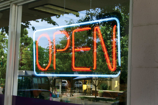 An open sign on a small business store window.