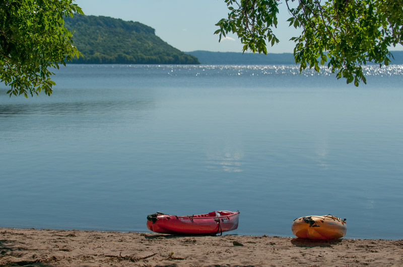 Kayaks on the beach of a lake.